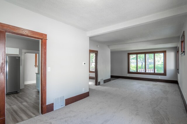 188 Wyoming St E, Saint Paul, MN 55107 - empty room with carpet floors, baseboards, a textured ceiling, and beamed ceiling