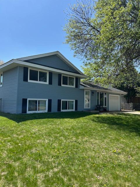 split level home with a garage and a front lawn
