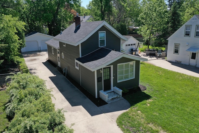 711 3rd St SE, Willmar, MN 56201 - view of front facade with roof with shingles, a chimney, a detached garage, an outbuilding, and entry steps