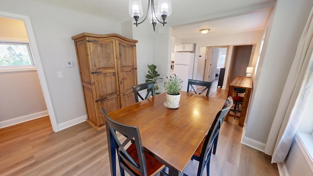 711 3rd St SE, Willmar, MN 56201 - dining area featuring a chandelier, light wood-style flooring, and healthy amount of natural light