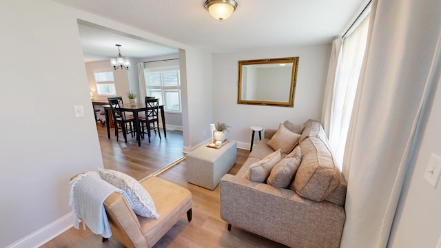 711 3rd St SE, Willmar, MN 56201 - living area with a chandelier, wood finished floors, and baseboards
