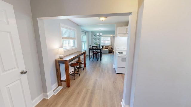 711 3rd St SE, Willmar, MN 56201 - hall with light wood-style floors, baseboards, and a chandelier