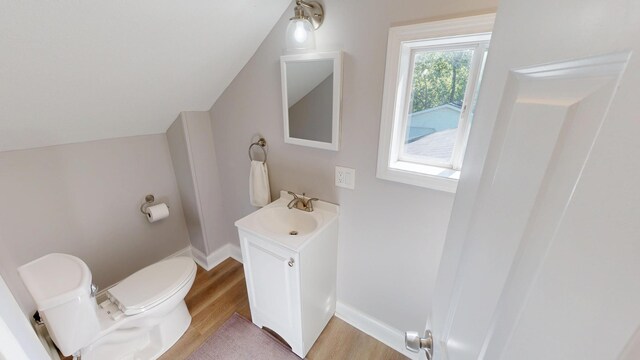 711 3rd St SE, Willmar, MN 56201 - half bathroom featuring vanity, toilet, wood finished floors, and baseboards