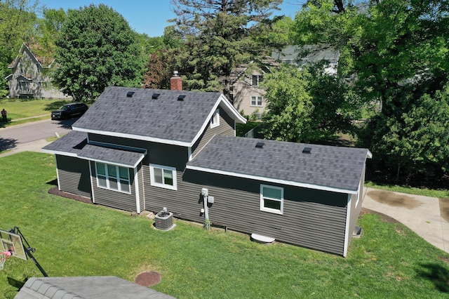 711 3rd St SE, Willmar, MN 56201 - rear view of house with roof with shingles, a lawn, and a chimney