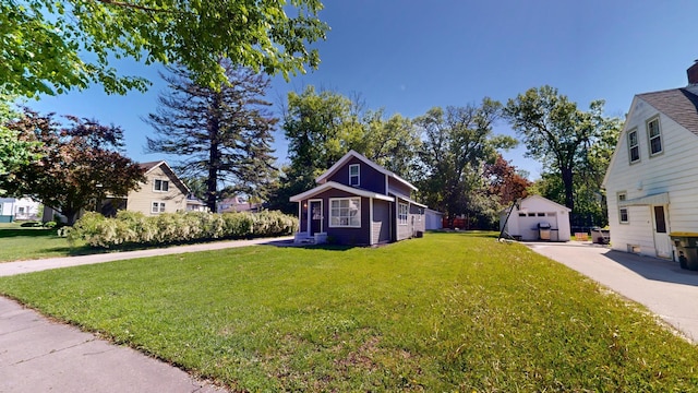 711 3rd St SE, Willmar, MN 56201 - view of grassy yard with an outbuilding, a detached garage, and driveway