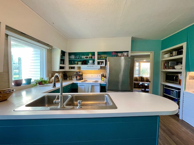 kitchen with appliances with stainless steel finishes, a sink, open shelves, a textured ceiling, and dark wood-style floors