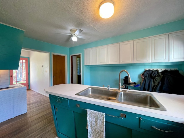 kitchen featuring a sink, light countertops, white cabinets, and a textured ceiling