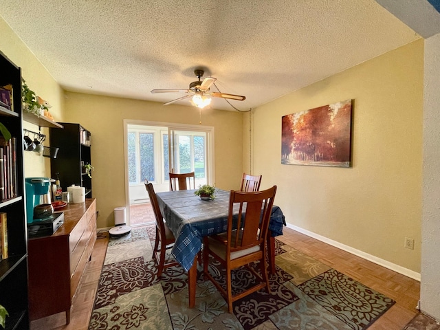 dining area featuring a ceiling fan, a textured ceiling, and baseboards