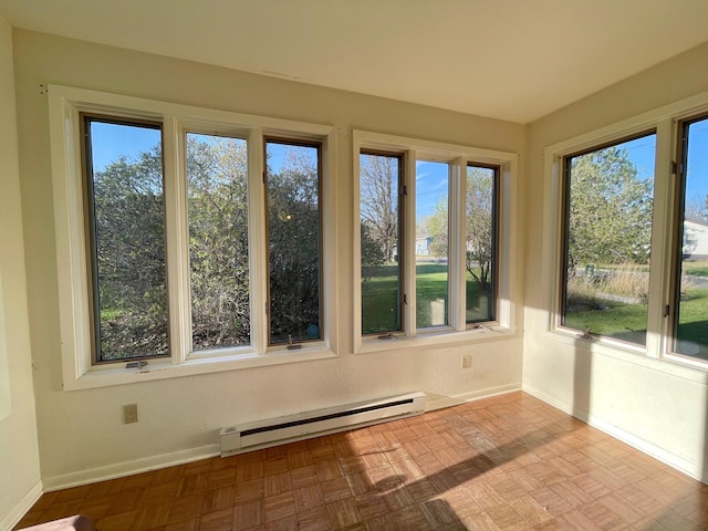 unfurnished sunroom with a baseboard heating unit, baseboards, and healthy amount of natural light