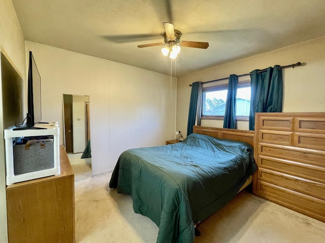 bedroom with light carpet and a ceiling fan