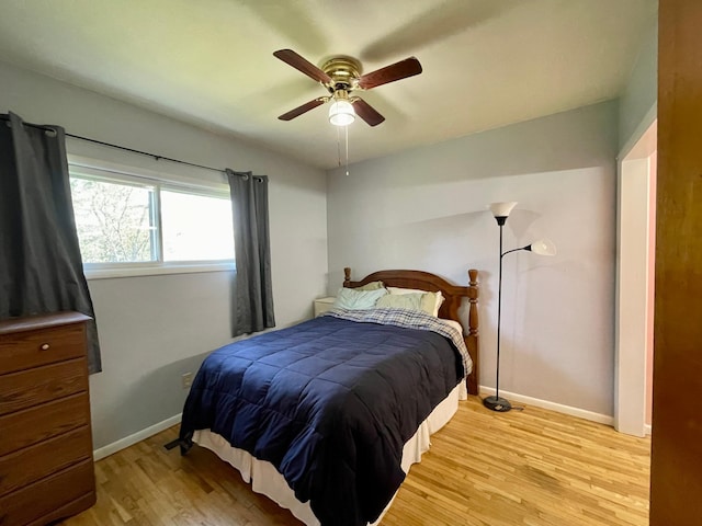 bedroom with light wood finished floors, baseboards, and a ceiling fan