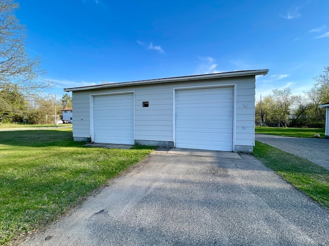 detached garage with asphalt driveway