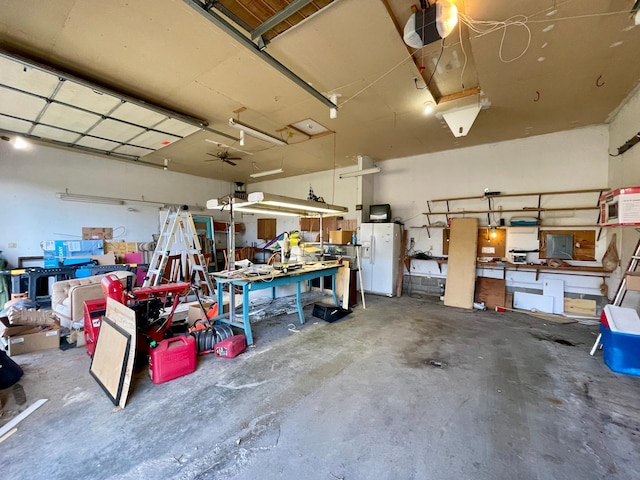 garage with white refrigerator with ice dispenser, a garage door opener, and a workshop area