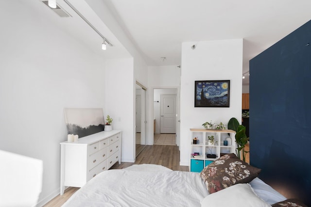 bedroom featuring light wood finished floors and baseboards