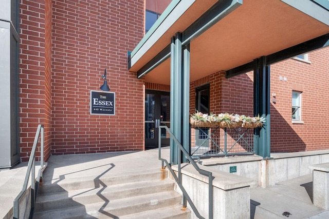 doorway to property featuring brick siding