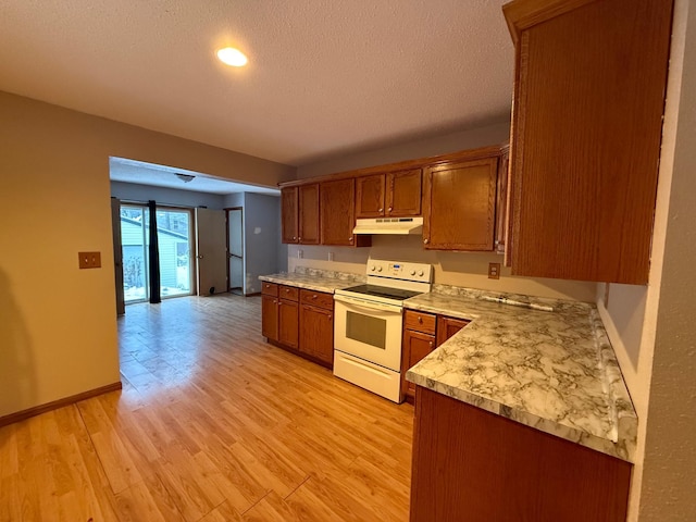 122 7th St, Montevideo, MN 56265 - kitchen featuring electric range, under cabinet range hood, light countertops, brown cabinets, and light wood-style flooring