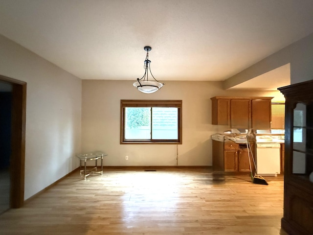 122 7th St, Montevideo, MN 56265 - unfurnished dining area with light wood-style floors and baseboards