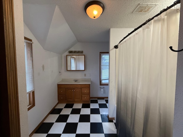 122 7th St, Montevideo, MN 56265 - full bath featuring tile patterned floors, vanity, baseboards, a textured ceiling, and lofted ceiling