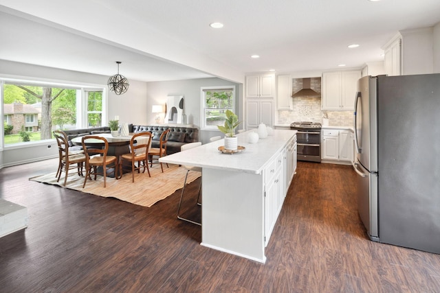 18120 Hummingbird Rd, Deephaven, MN 55391 - kitchen with appliances with stainless steel finishes, wall chimney range hood, white cabinets, a center island, and dark wood-style flooring