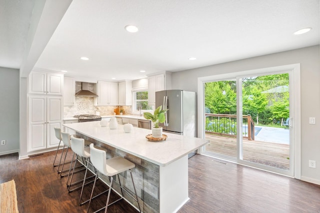 18120 Hummingbird Rd, Deephaven, MN 55391 - kitchen featuring wall chimney range hood, white cabinetry, backsplash, dark wood-type flooring, and recessed lighting