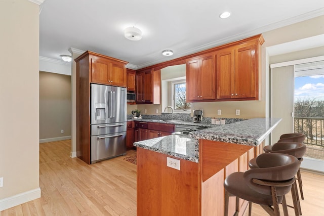 5230 Rebecca Park Trl, Greenfield, MN 55357 - kitchen featuring appliances with stainless steel finishes, a peninsula, ornamental molding, baseboards, and stone counters