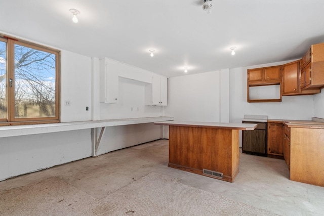 5230 Rebecca Park Trl, Greenfield, MN 55357 - kitchen featuring unfinished concrete floors, a kitchen island, light countertops, and brown cabinets