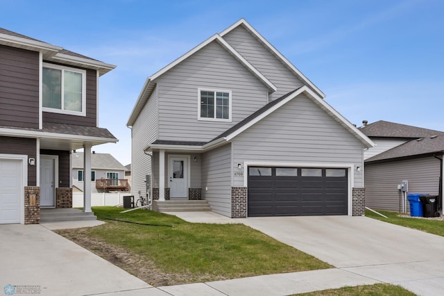 view of front of house with brick siding, driveway, a front yard, a garage, and central air condition unit