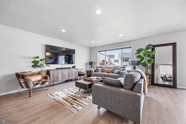 living room featuring light wood finished floors, baseboards, and recessed lighting