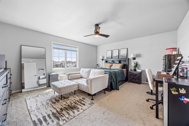 carpeted bedroom featuring a desk, ceiling fan, and baseboards