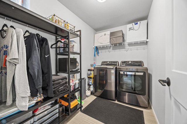 laundry area with washer and clothes dryer, wood finished floors, and baseboards