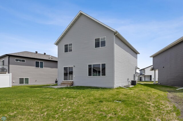 back of property featuring entry steps, cooling unit, and a yard