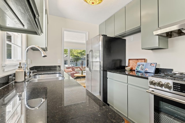 343 41st St, Minneapolis, MN 55409 - kitchen featuring appliances with stainless steel finishes, a sink, wall chimney range hood, and dark stone counters