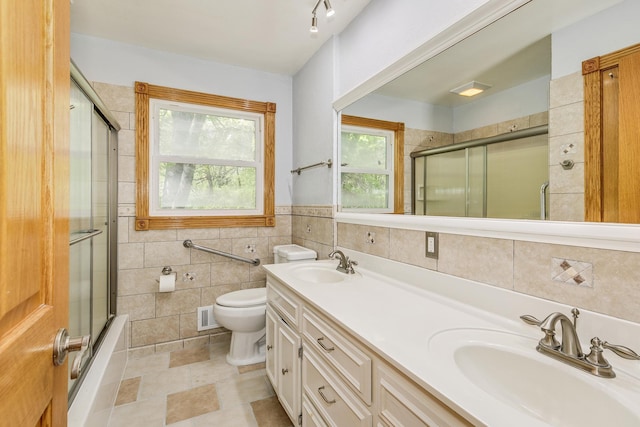 2000 191st Ave NW, Oak Grove, MN 55011 - full bath featuring tile walls, toilet, double vanity, tile patterned flooring, and shower / bath combination with glass door