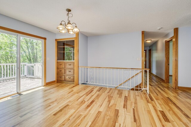 2000 191st Ave NW, Oak Grove, MN 55011 - spare room featuring wood finished floors, baseboards, a chandelier, and a smoke detector