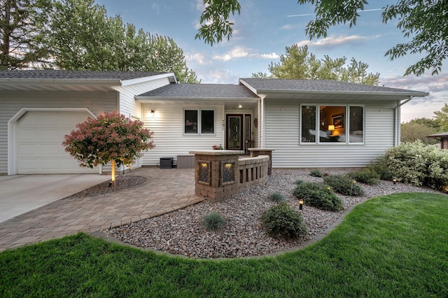 791 Highland Rd, Windom, MN 56101 - view of front of property with an attached garage, concrete driveway, central AC unit, roof with shingles, and a front yard