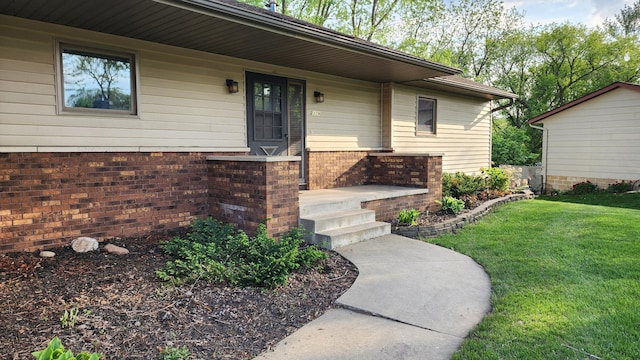 2339 2nd Ave SW, Rochester, MN 55902 - view of exterior entry featuring a yard and brick siding