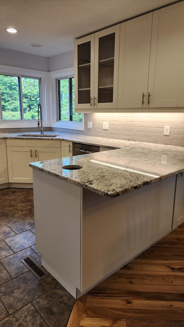 2339 2nd Ave SW, Rochester, MN 55902 - kitchen featuring a sink, light stone counters, glass insert cabinets, tasteful backsplash, and recessed lighting