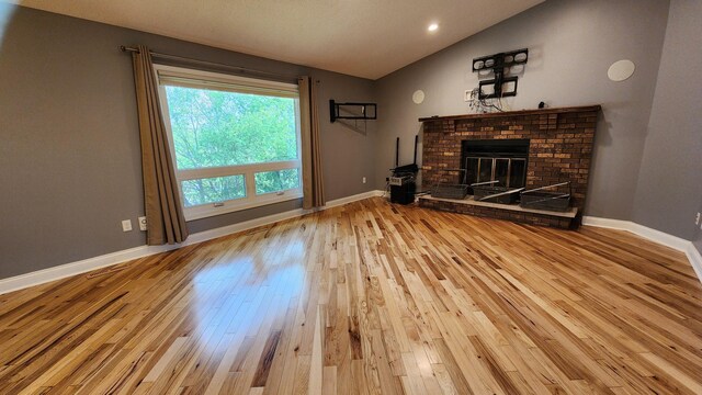 2339 2nd Ave SW, Rochester, MN 55902 - unfurnished living room featuring lofted ceiling, wood finished floors, a brick fireplace, baseboards, and recessed lighting