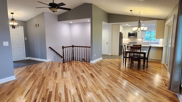 2339 2nd Ave SW, Rochester, MN 55902 - dining room featuring a chandelier, vaulted ceiling, light wood-style flooring, ceiling fan, and baseboards
