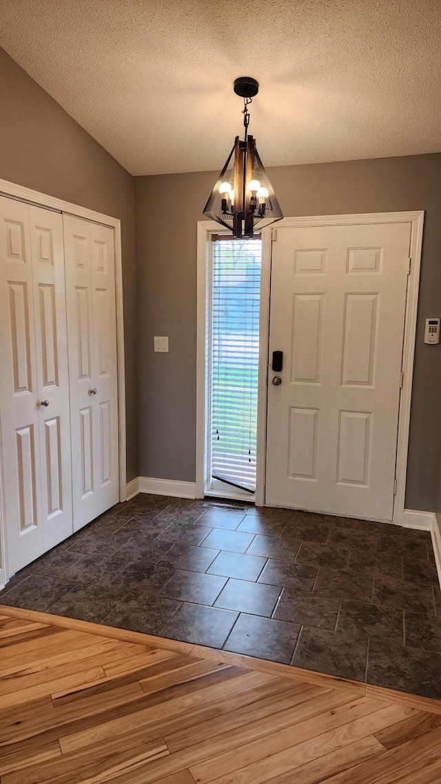 2339 2nd Ave SW, Rochester, MN 55902 - foyer with a chandelier, baseboards, a textured ceiling, and dark wood-style flooring