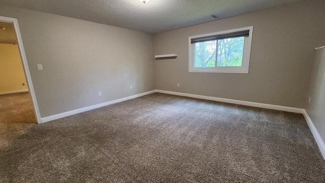 2339 2nd Ave SW, Rochester, MN 55902 - empty room featuring dark colored carpet, baseboards, and a textured ceiling