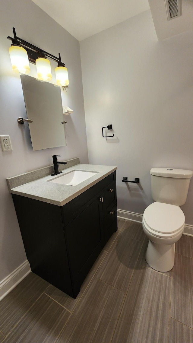 2339 2nd Ave SW, Rochester, MN 55902 - half bathroom with toilet, vanity, baseboards, and wood finished floors