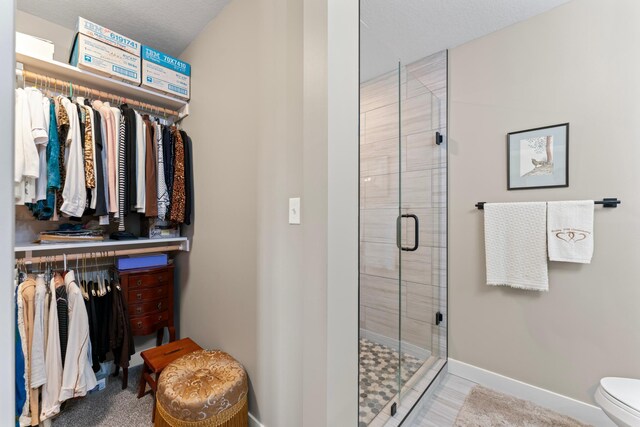 409 10th St NW, Dodge Center, MN 55927 - bathroom with a stall shower, baseboards, and toilet