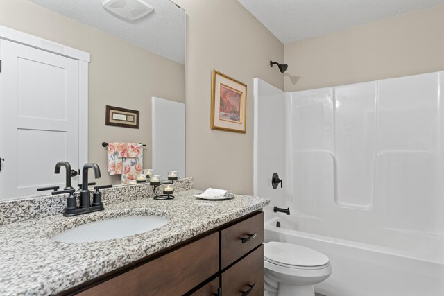 409 10th St NW, Dodge Center, MN 55927 - bathroom with toilet, vanity, shower / bath combination, and a textured ceiling