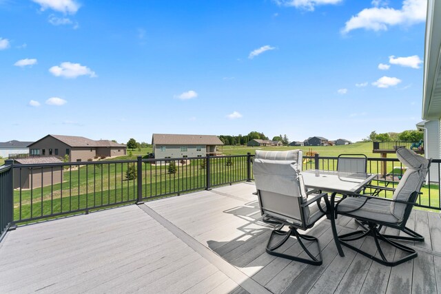 409 10th St NW, Dodge Center, MN 55927 - wooden deck featuring a residential view, outdoor dining area, and a yard