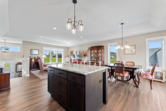 409 10th St NW, Dodge Center, MN 55927 - kitchen with a chandelier, a raised ceiling, wood finished floors, hanging light fixtures, and recessed lighting