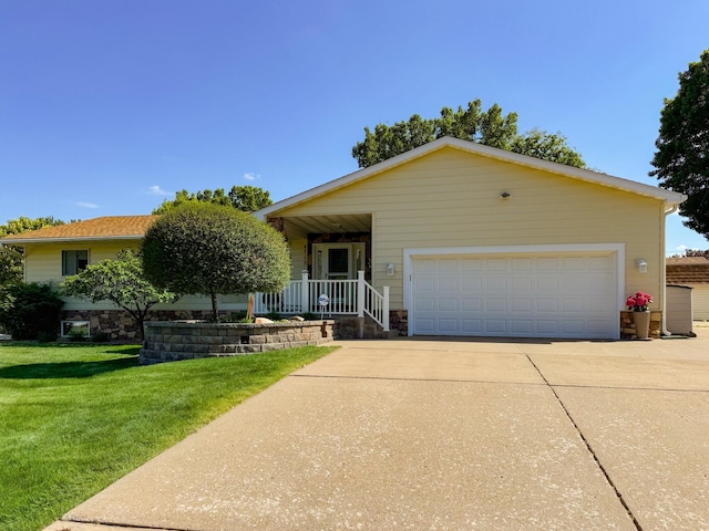 view of front of house with a front lawn, covered porch, an attached garage, stone siding, and concrete driveway