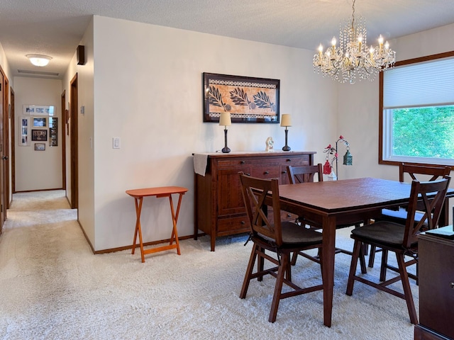 dining space with light colored carpet and a chandelier