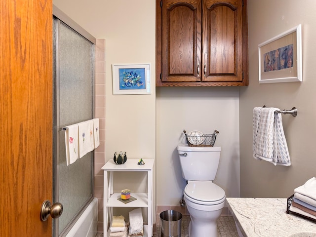 full bath with toilet, baseboards, and bath / shower combo with glass door