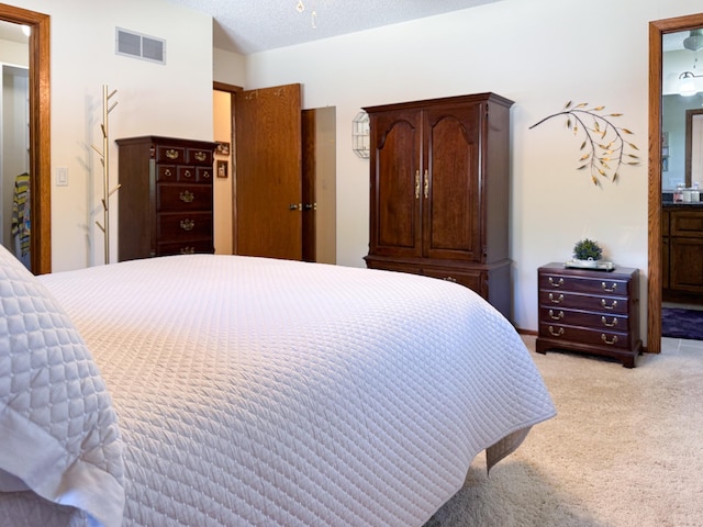 bedroom featuring light colored carpet and connected bathroom
